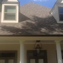 Porch roofline with white columns below a dormered roof